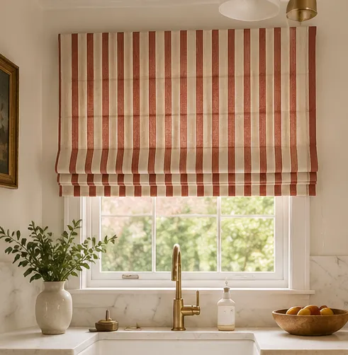 A red and cream ticking-stripe Roman blind above a marble kitchen counter